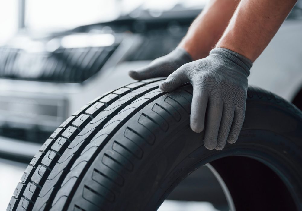 hands-only-mechanic-holding-tire-repair-garage-replacement-winter-summer-tires (1)